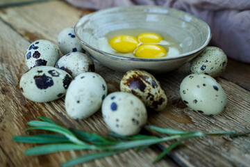 Fresh quail eggs surround a bowl with three golden yolks, highlighting natures bounty on a rustic wooden surface.