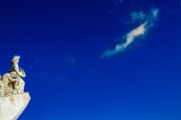 Fototapeta premium Exploring the intricate carvings of the Monument of the Discoveries in Lisbon, Portugal against a stunning blue sky