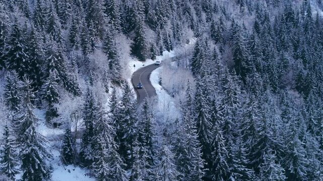 An aerial view highlights a winding road through snowcovered trees in Courchevel, France, capturing the essence of winters beauty and charm that attracts many visitors to this alpine destination