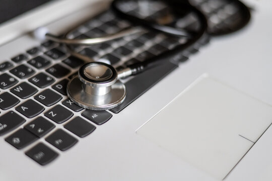 Stethoscope lying on a laptop keyboard suggesting online medical consultation, remote diagnosis, or healthcare technology, combining medical expertise with digital accessibility