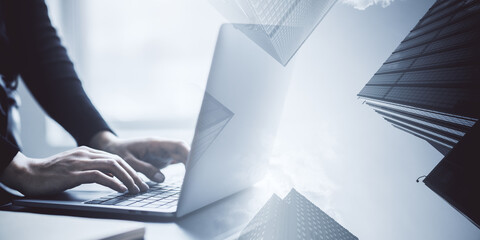 Businesswoman working on laptop with cityscape overlay.