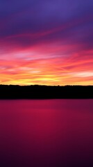 Obraz premium A High-Resolution Wallpaper Depicting A Serene Landscape At Sunset, Featuring A Vibrant Gradient Of Orange, Pink, And Purple Hues Across The Sky, Reflecting On A Calm Body Of Water, .