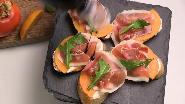 Sandwiches with slices of ham jamon iberico, fresh toast. The chef decorates the appetizer with sauce. Top view.