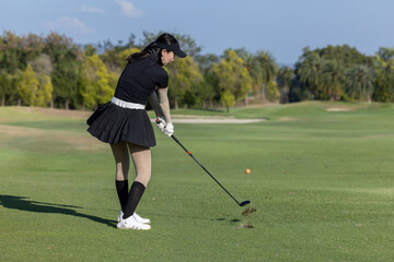 Asian woman professional golfer play golf at golf course with green golf course background, Asian...