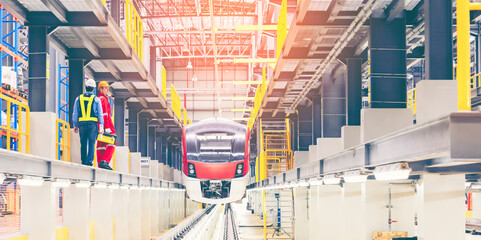 Electric train technician engineer with blueprints checking controls system for security functions...
