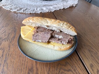 Turkish toast sandwich with kavurma meat on wooden table