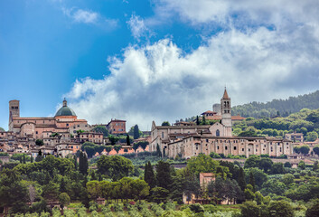 Medieval architecture and scenic views of San Rufino Cathedral in Assisi under a blue cloudy sky