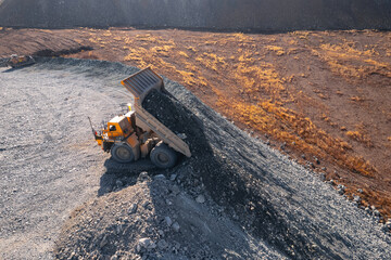 Big yellow mining truck transportation of gold and iron, copper ore. Open pit mine industry, aerial...