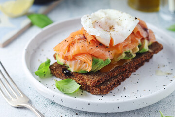 A rye bread sandwich with avocado and salmon