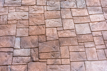 The stone wall is patterned in light brown tones, each cube is different, small and large alternately.