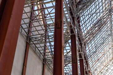 Obraz premium Uprisen angle photo shot of the huge steel roof frame structure detail under construction at the work site.