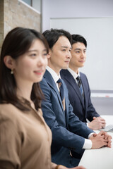 Horizontal profile of a team of men and women working in an office, looking toward the future and...