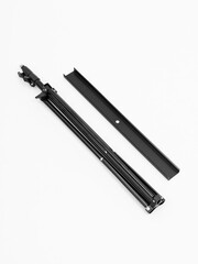 Black tripod with a metal comb. White background.