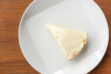 Clear Coconut Cream Pie in the dish on the wood table without anything topping on it. Shooting in the sunlight.