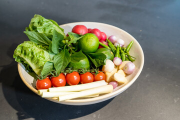 Ingredients of Spicy salad are prepared on black granite top table with various vegetable and herb.