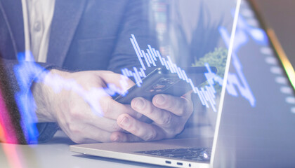 Mobile financial analysis: hands using smartphone and laptop with digital visualization of stock market data