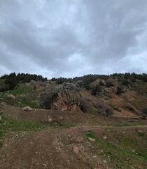 Dramatic cloudy sky over rocky hillside landscape