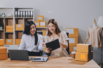 Startup SME small business entrepreneur of freelance Asian woman using a laptop with box Cheerful...