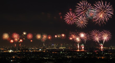 Fototapeta premium Spectacular cityscape illuminated by a vibrant fireworks display at night