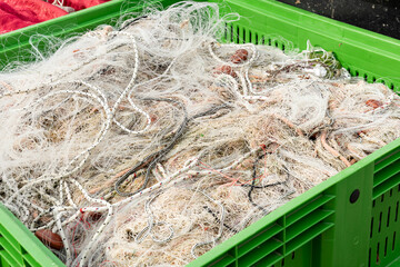 fishing nets lying in a dumpster on the pier.