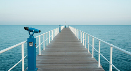 Obraz premium Seaside pier extending into the horizon with calm waters