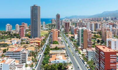 Naklejka premium Aerial view of Benidorm cityscape with coastal road, buildings, and sea