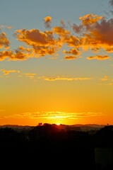 Dawn with reddish clouds in the sky. Sun rising over the horizon, yellow reflections in the sky.