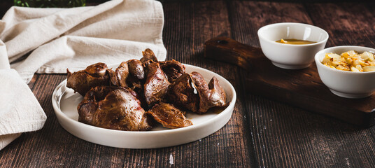 Pieces of fried chicken liver on a plate on the table web banner
