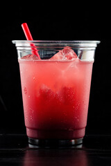 Red drink cocktail or lemonade with ice in a glass