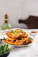 Baked toasts with bacon, cheese and tomato sauce on a plate on the table vertical view