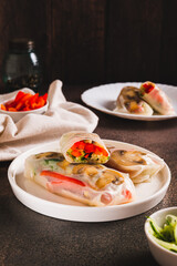 Vegetarian spring rolls with cucumber, pepper and fried mushrooms on a plate vertical view