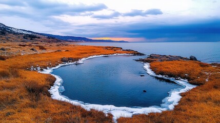 Serene Winter Landscape with Ice, Water, and Orange Grass at Dusk