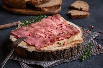Sliced pastrami meat with rosemary and pepper