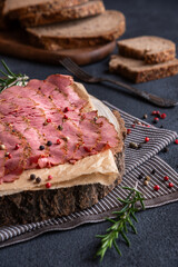 Sliced pastrami meat with rosemary and pepper