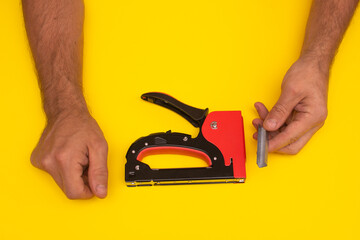 stapler for furniture upholstery on a yellow background.