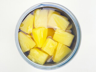 A closeup, overhead, centred and isolated shot of an open tin can of chopped pineapple chunks in...