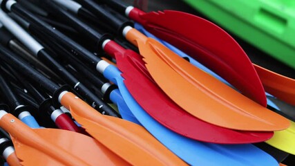 Stack of colorful kayak oars.