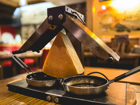 Un appareil &agrave; raclette ancien avec une meule de fromage dans un restaurant.
