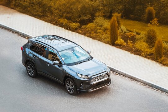 Modern car driving near parked vehicles