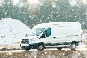 Cargo van driving past snow and trees © AlexGo