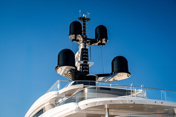 Close up view of the radar navigation system and communication mast on a white modern super mega...