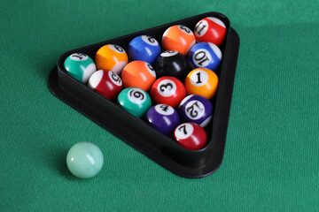 Billiard balls triangle rack on green table, closeup
