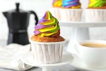 Delicious cupcake with colorful cream on stand, closeup