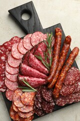 Different smoked sausages slices served on light table, top view