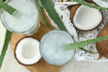 Refreshing drink with coconut and aloe on white textured table, flat lay