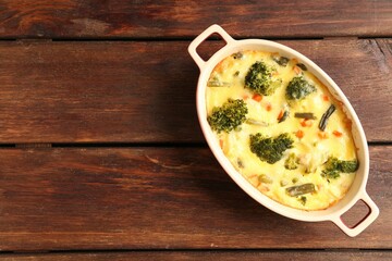 Delicious vegetable casserole on wooden table, top view. Space for text