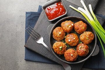 Tasty meatballs served on grey table, flat lay