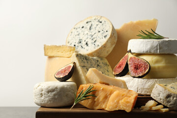 Different types of cheese, rosemary and figs on table, closeup