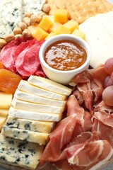 Different types of cut cheese and other snacks, closeup