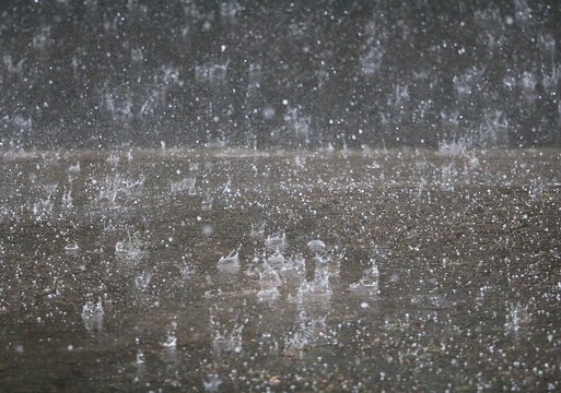 heavy rain falls on the street and splashes in the puddles